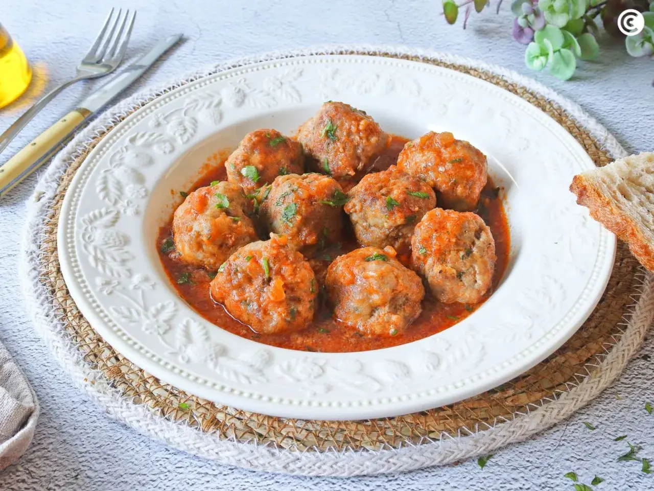 Albóndigas en salsa de la abuela, jugosas y caseras, servidas en un plato blanco con un borde decorado. Un clásico reconfortante.