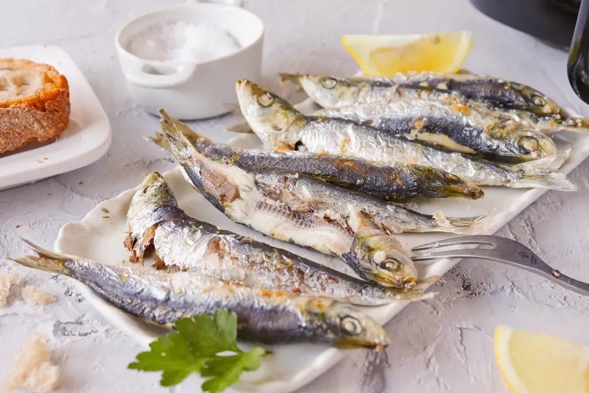 Sardinas empanadas, doradas y crujientes, servidas con limón y pan. Un plato delicioso y saludable.