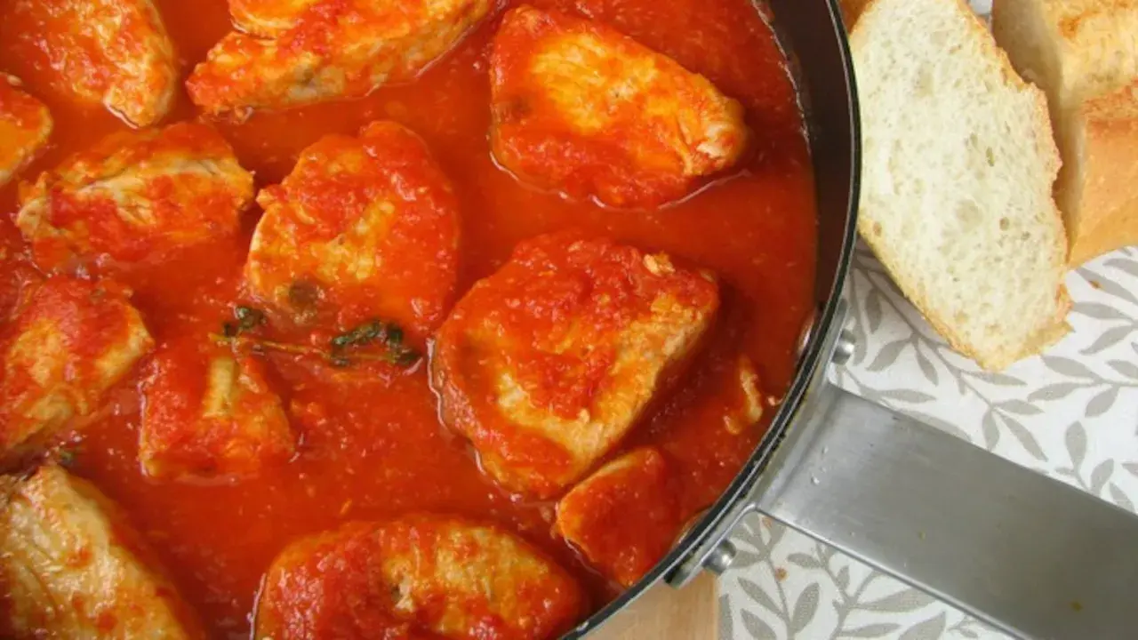 Bonito en salsa de tomate, un plato casero con trozos de pan.