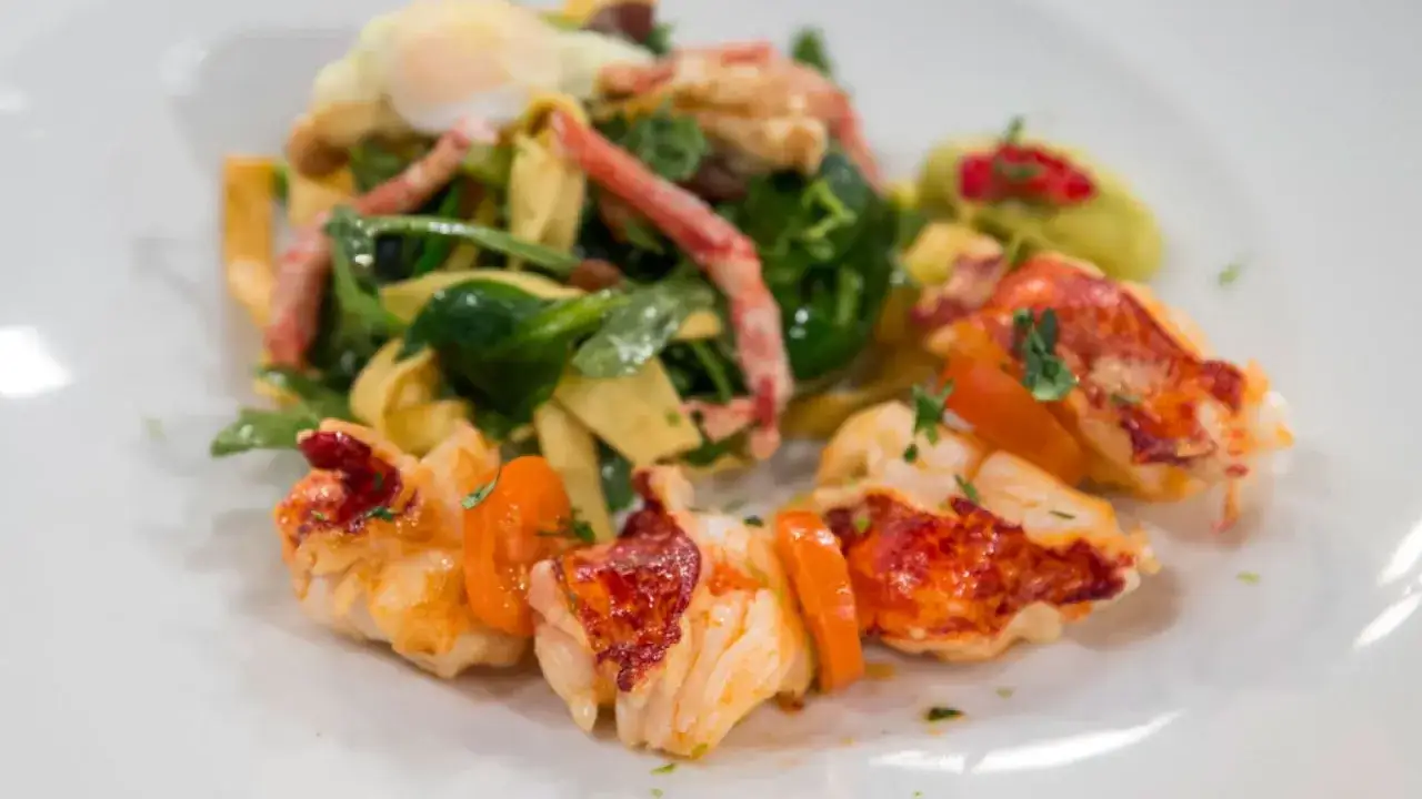 Exquisita ensalada de bogavante gourmet con pasta fresca, huevo escalfado y tomates cherry.