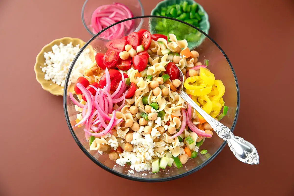 Deliciosa amanida de pasta con garbanzos, tomates cherry, pepino, cebolla morada y queso feta. &iexcl;Perfecta para un d&iacute;a caluroso!