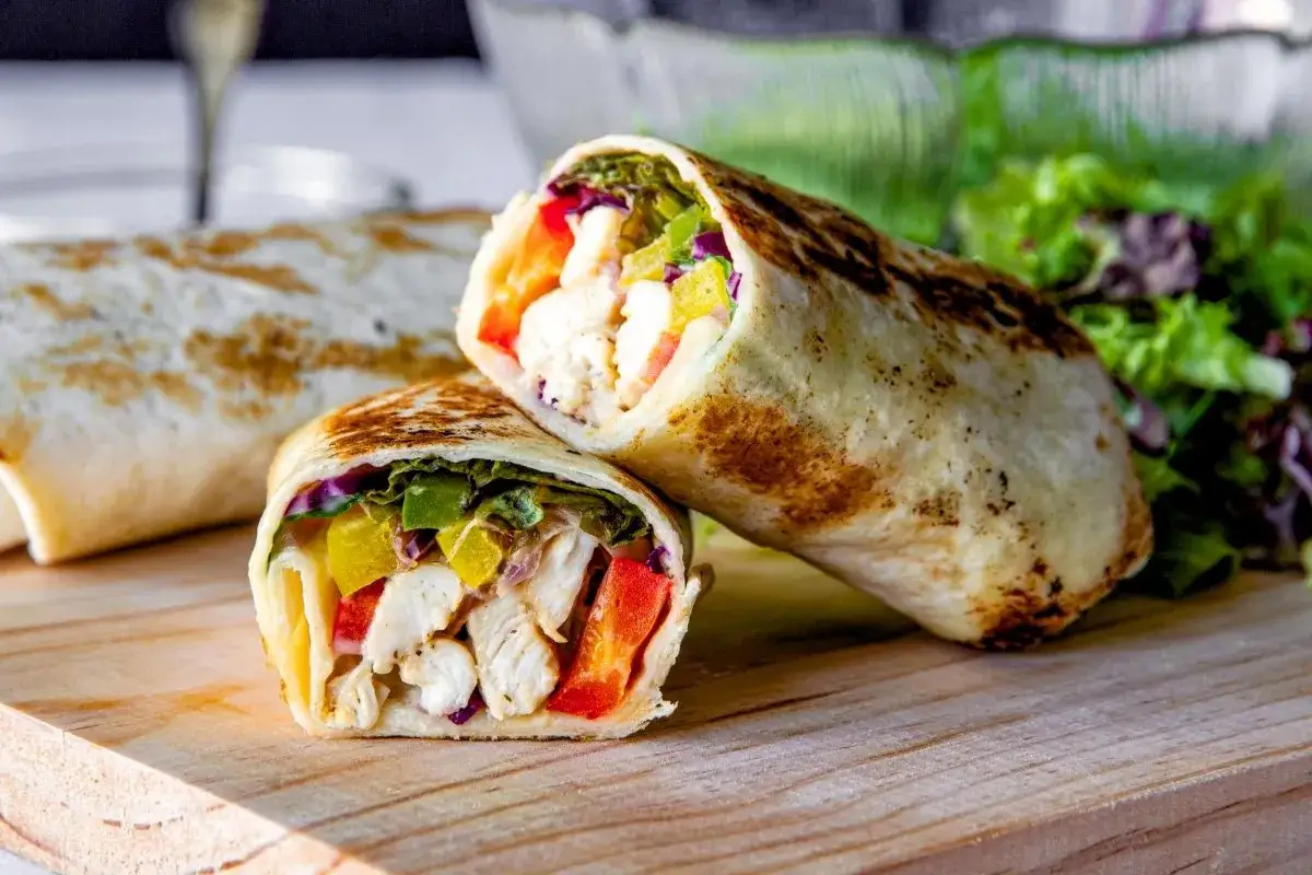 Delicioso wrap de pollo con verduras frescas y pimientos de colores. Un bocado perfecto para cualquier momento.