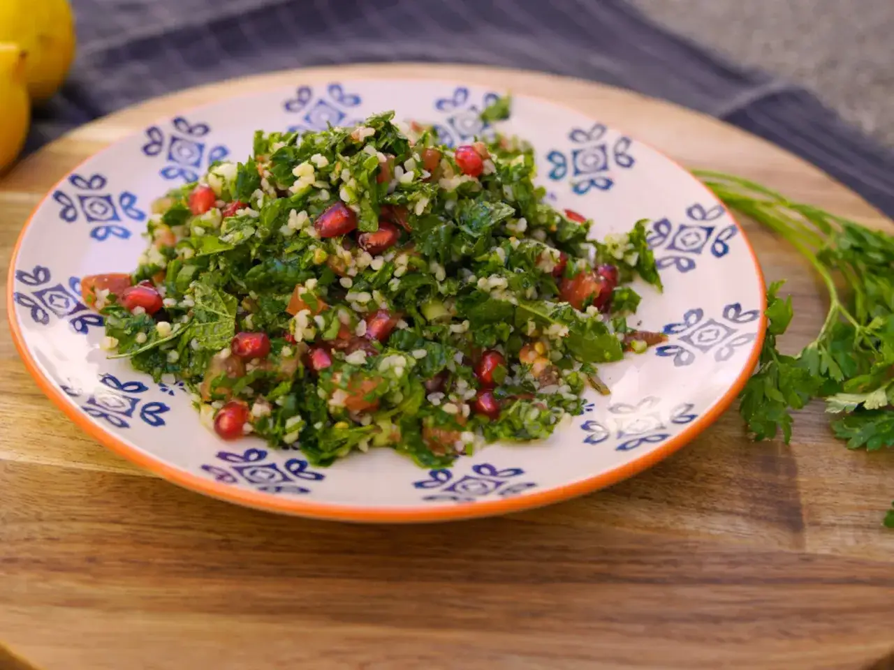 Delicioso tabule receta con perejil fresco, tomate, bulgur y granada, servido en un plato decorado.