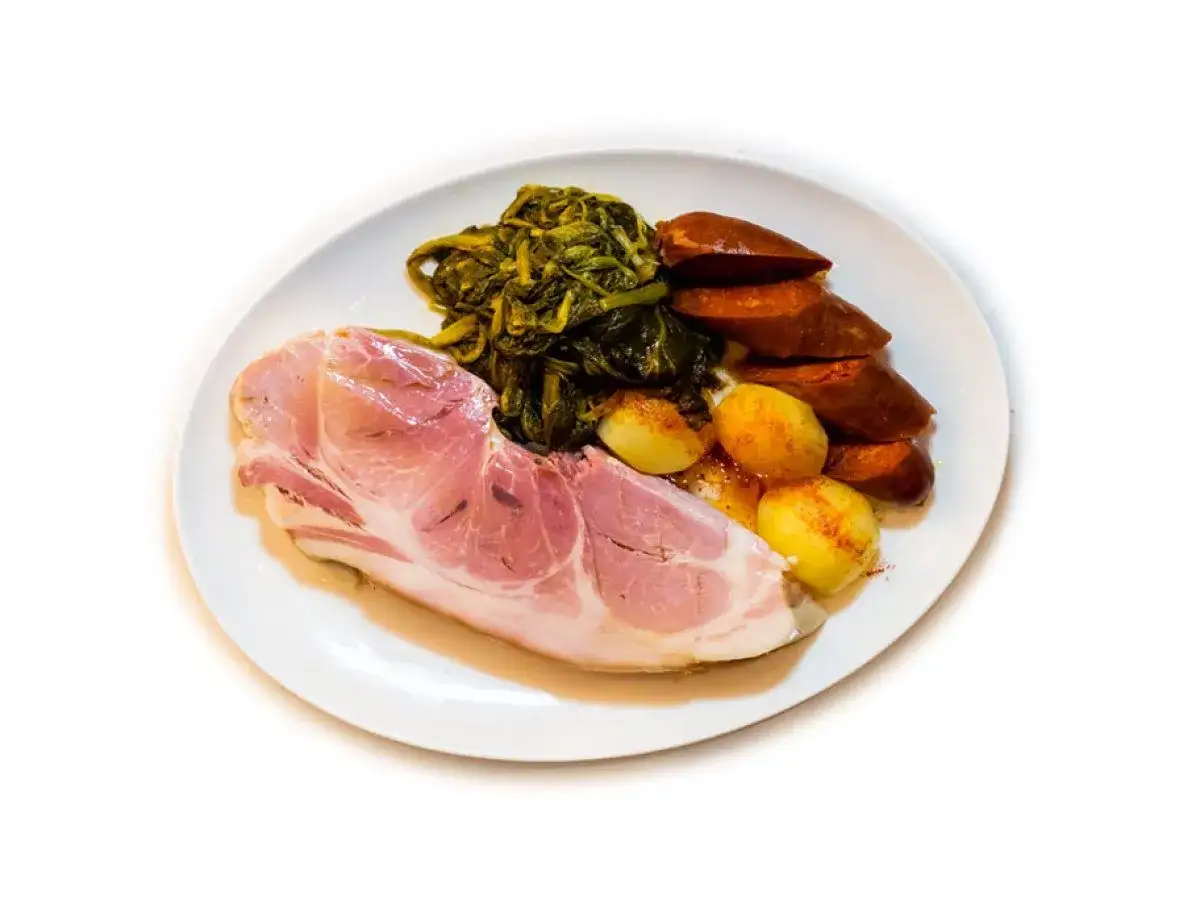 Un plato de lacon con grelos, acompa&ntilde;ado de chorizo y patatas.