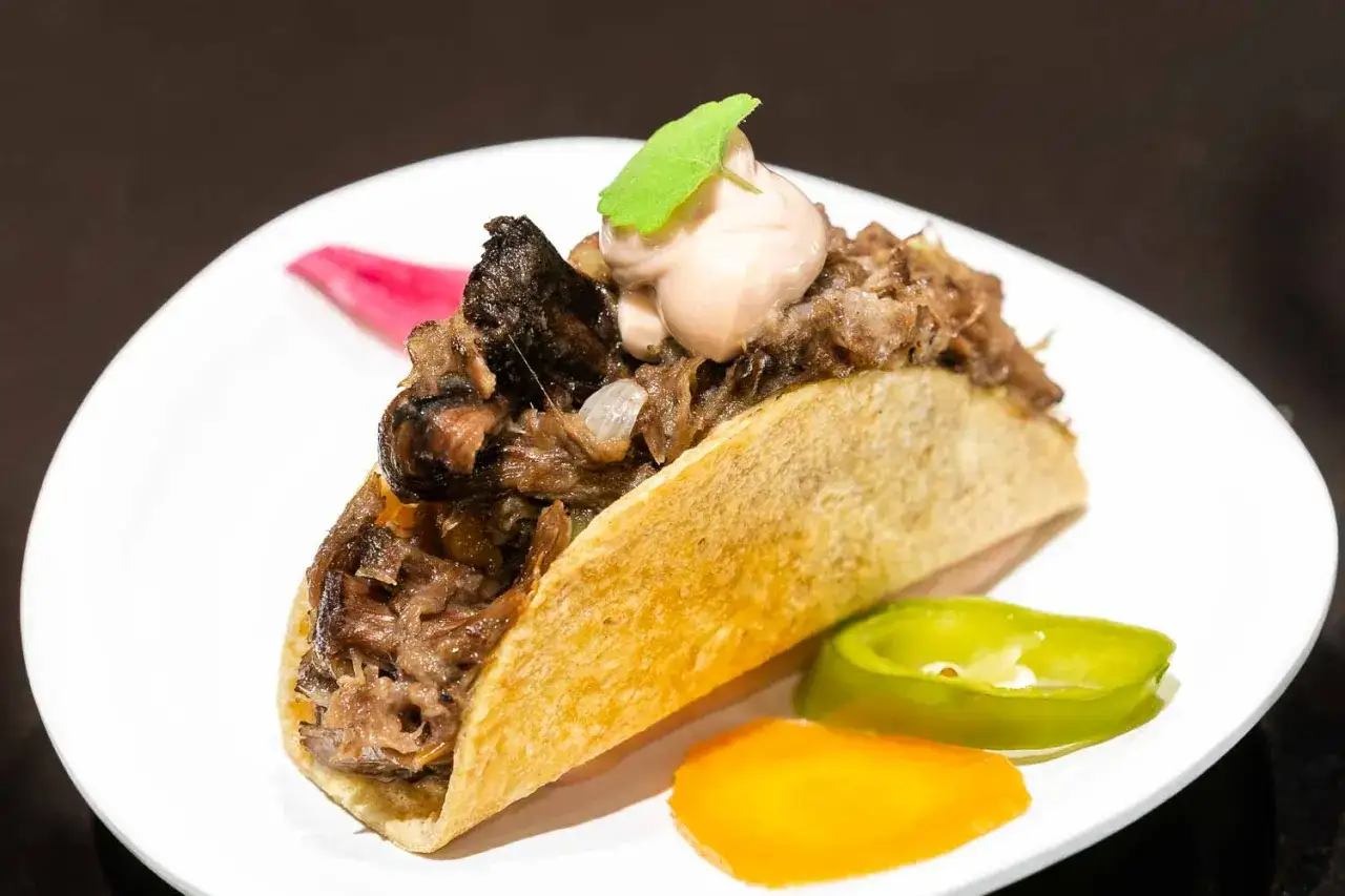 Tacos de rabo de toro, jugosa carne deshebrada en tortilla dorada, coronados con crema y una hoja verde. Acompa&ntilde;ados de jalape&ntilde;o y zanahoria.