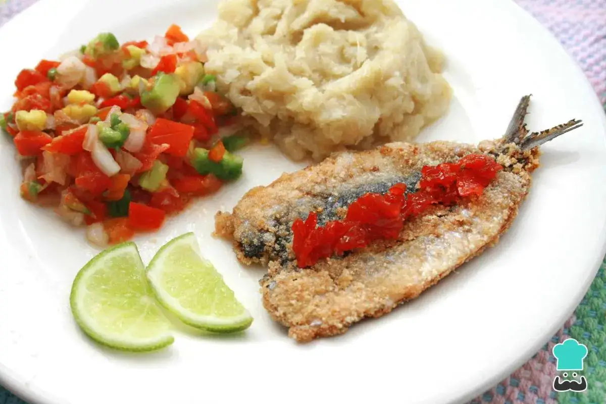 Deliciosas sardinas empanadas con puré, ensalada fresca y gajos de limón. Un plato lleno de sabor.