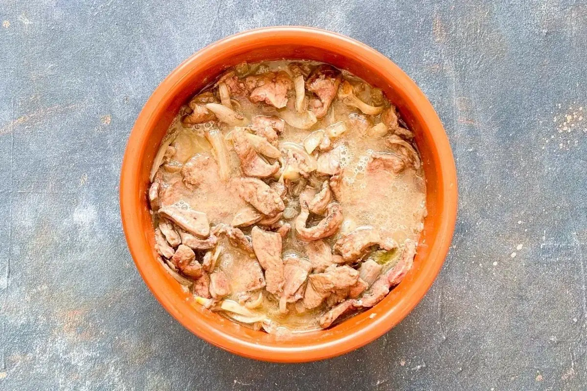 Un plato de barro con un delicioso h&iacute;gado encebollado, jugoso y lleno de sabor.