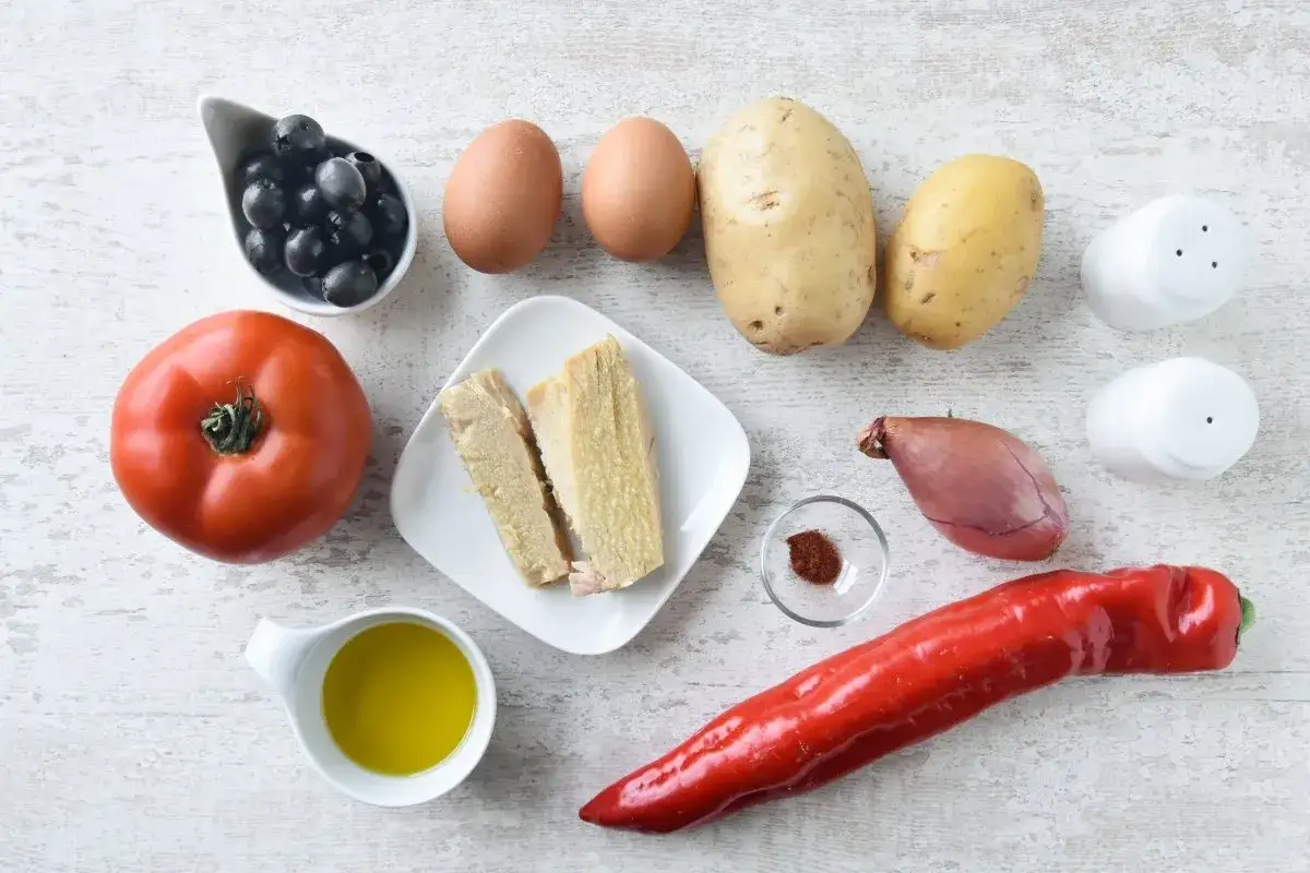 Ingredientes para una ensalada campera: patatas, huevos, tomate, pimiento rojo, aceitunas, cebolla, at&uacute;n, aceite, sal y piment&oacute;n.