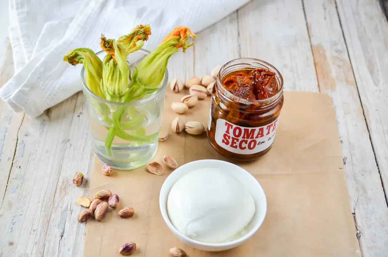 Flores de calabacín, tomates secos y pistachos listos para preparar un plato delicioso. El queso de bufala tiene lactosa.
